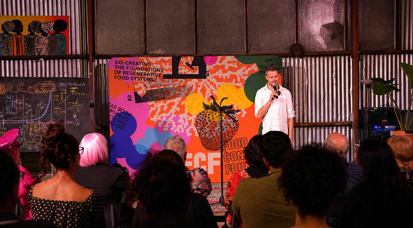 Kyal Neil Currant speaking on stage